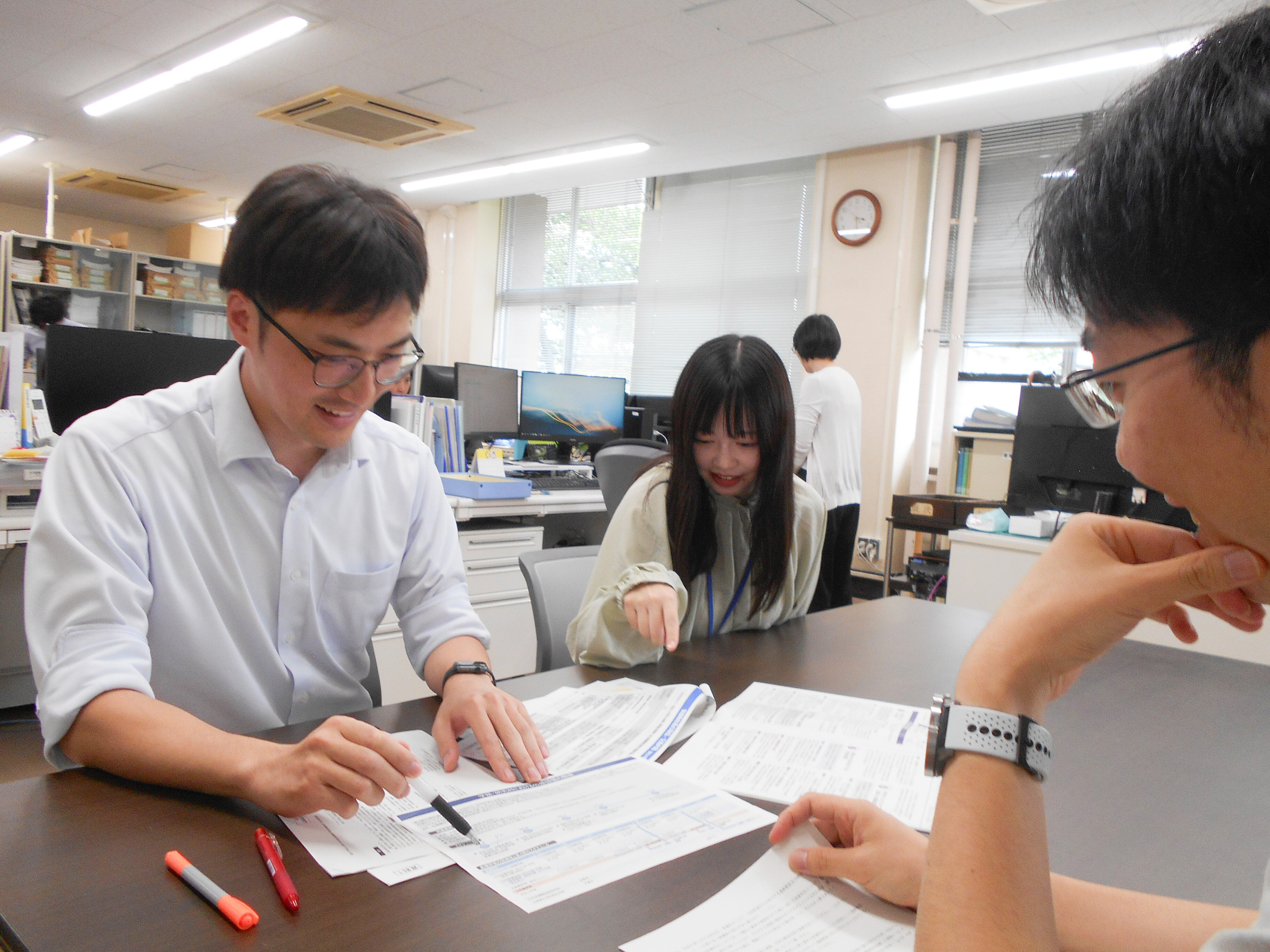 研修受講経験者を含め3人で打ち合わせをしている写真