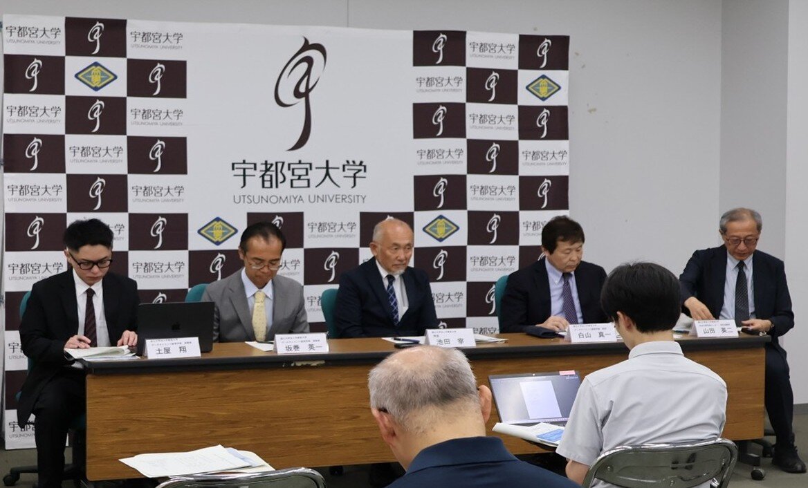 記者会見の壇上に並ぶ関係者の様子