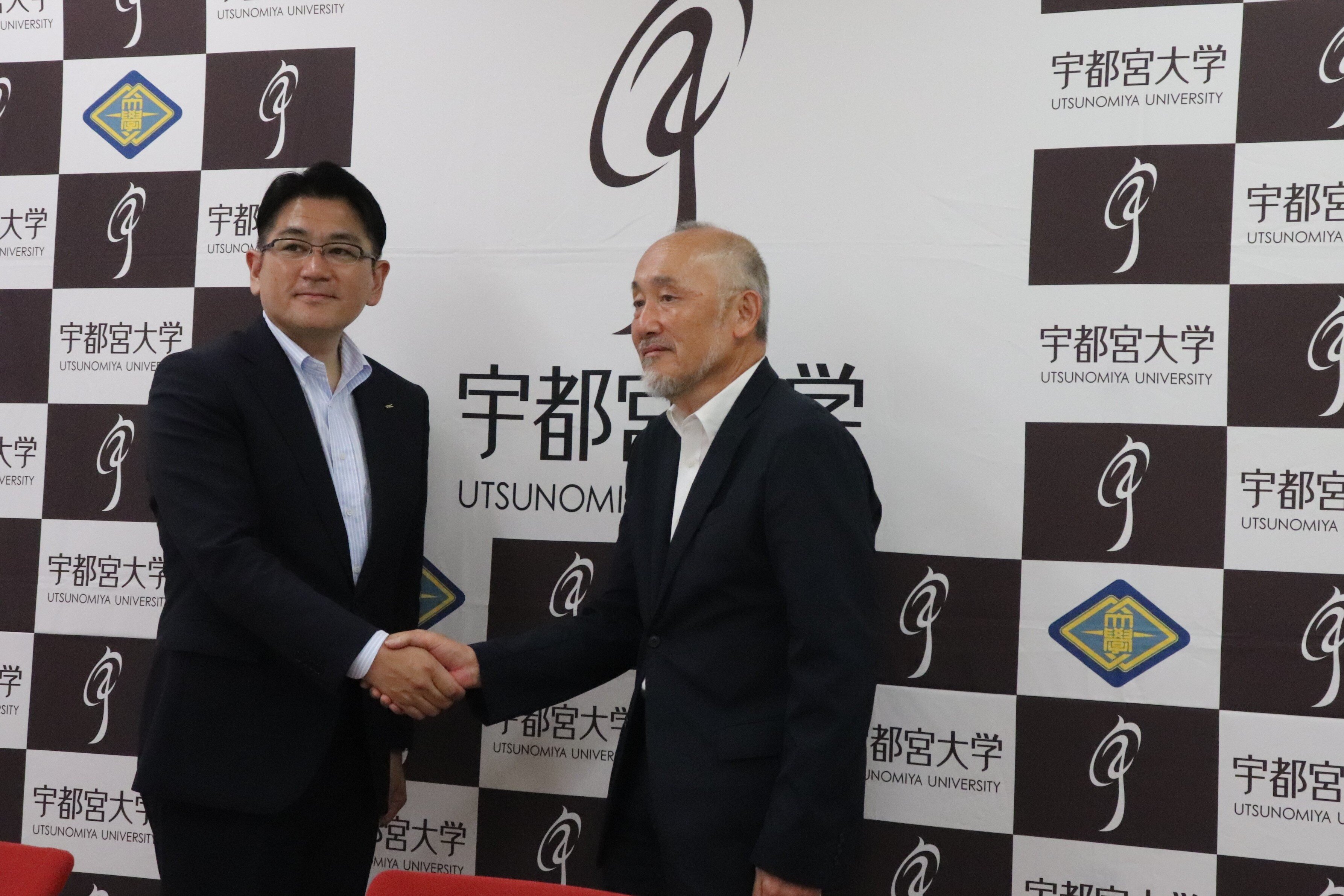 握手を交わす株式会社TKCの飯塚真規代表取締役社⻑と宇都宮大学の池田学長