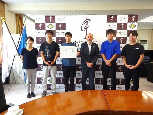 池田学長と軟式野球部学生の集合写真