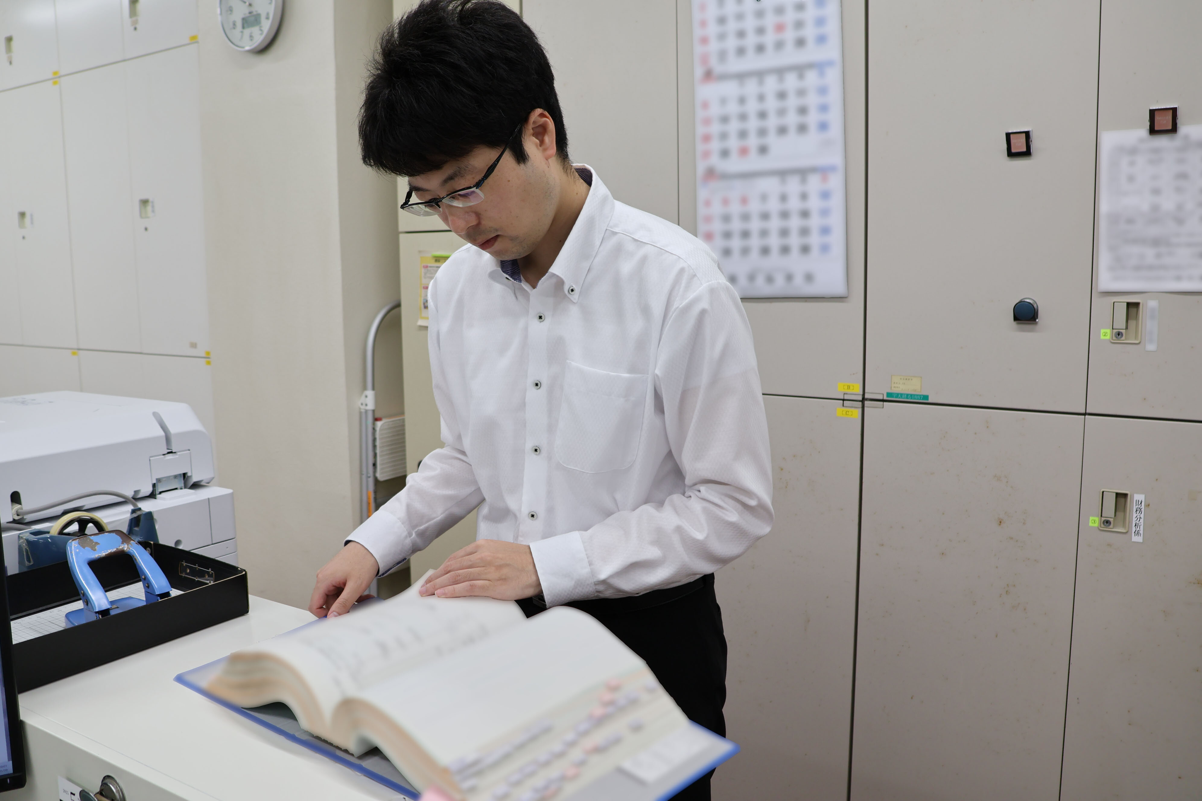 職員が紙ファイルを確認している写真